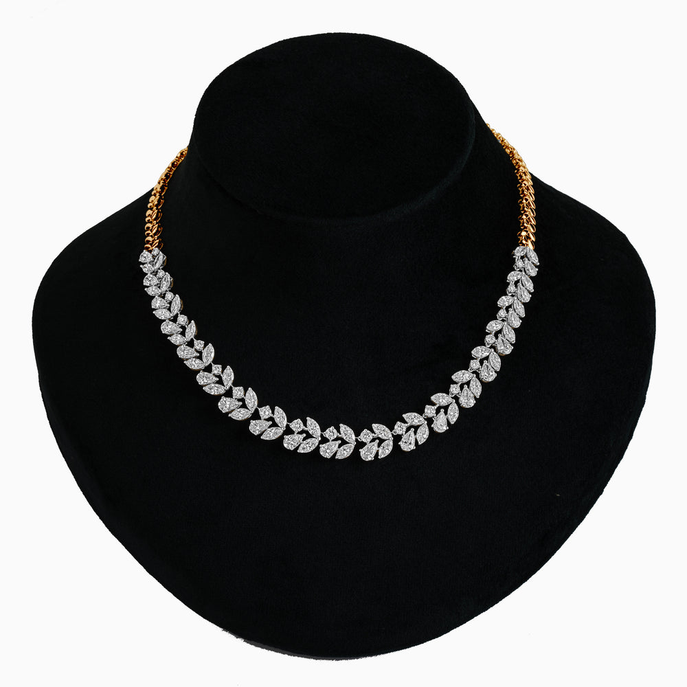 Diamond leaf-shaped necklace with gold chain on black display mannequin
