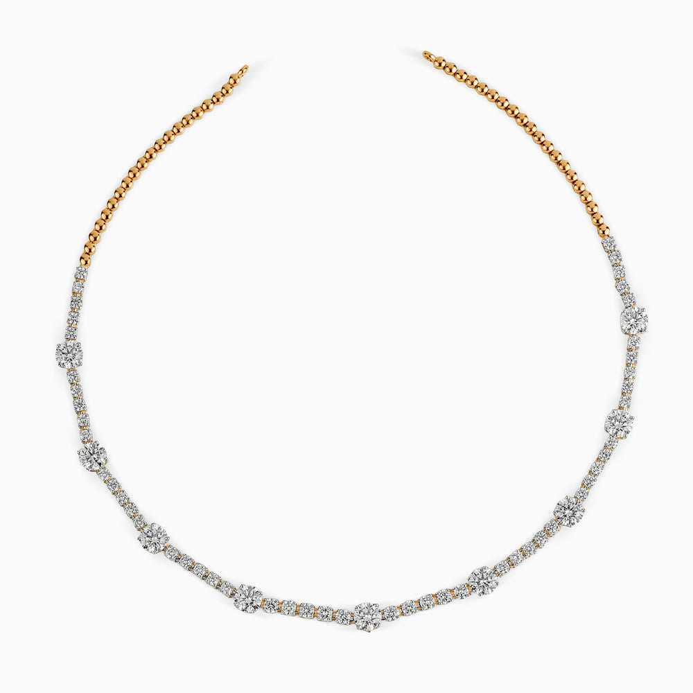 Gold and diamond tennis necklace with alternating large and small stones, elegant curved design