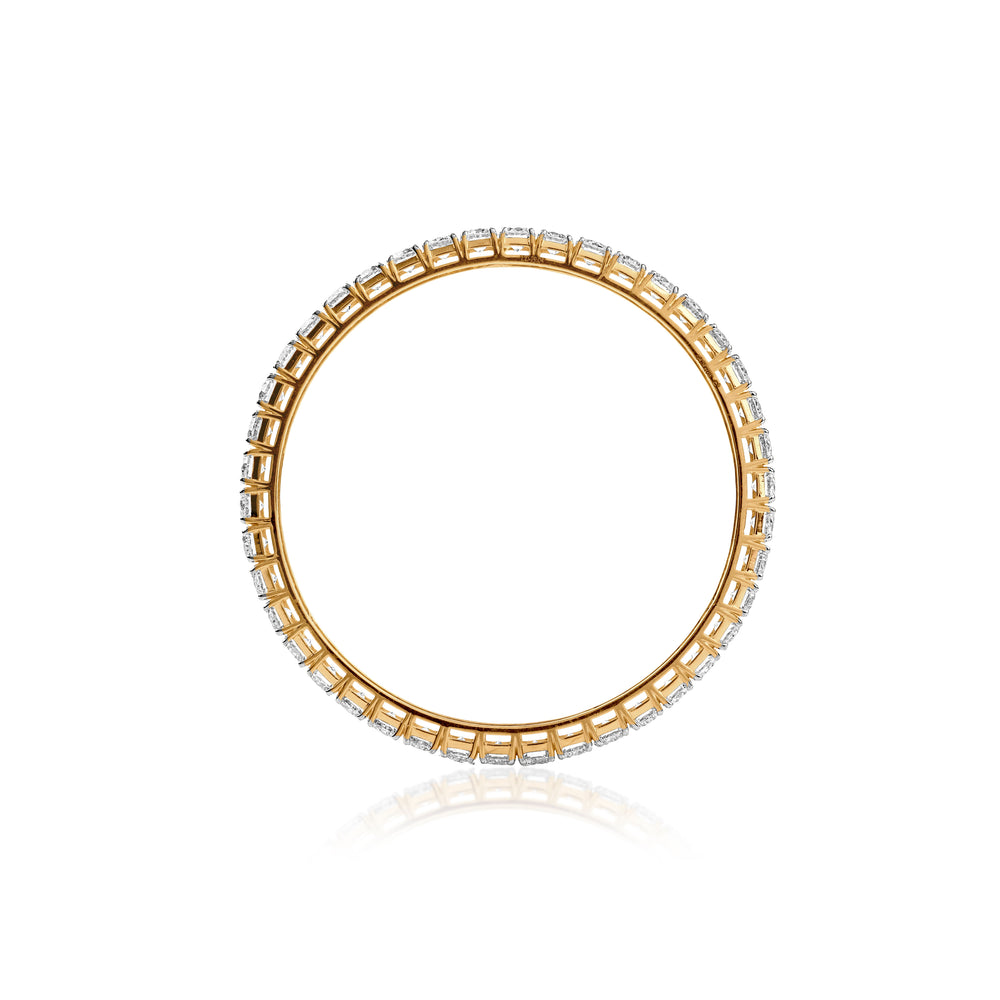 Gold eternity band with diamond stones in square settings, casting soft reflection