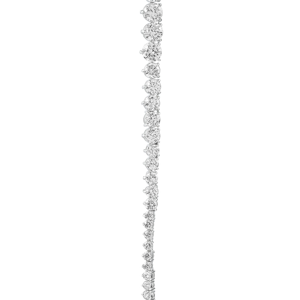 Vertical line of sparkling round diamonds set in white metal, gradually decreasing in size