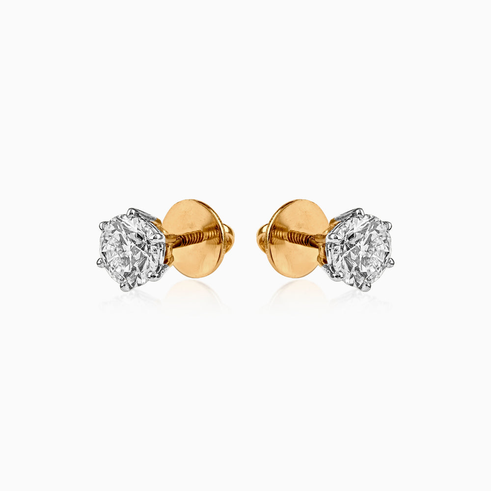 Pair of gold and silver diamond stud earrings with screw-back closure