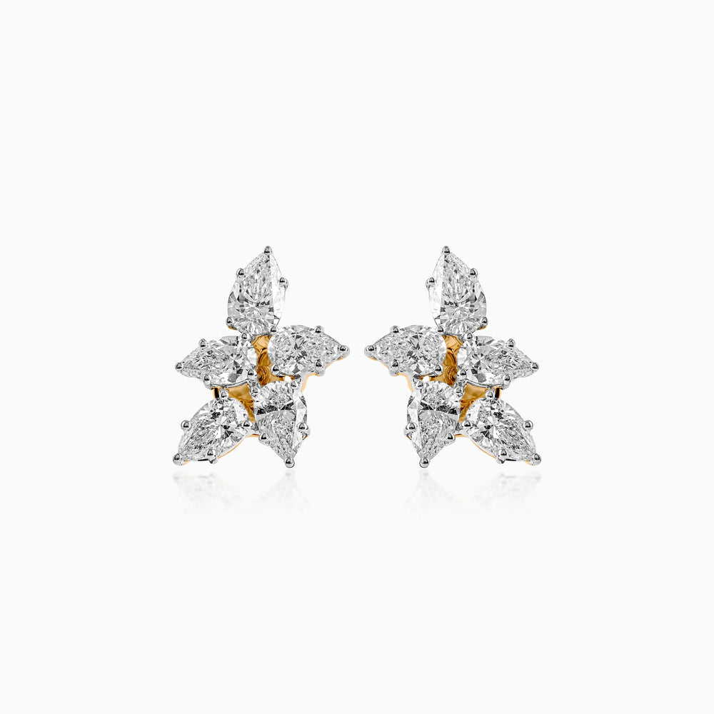 Diamond cluster earrings with gold and white gemstones in a star-like arrangement