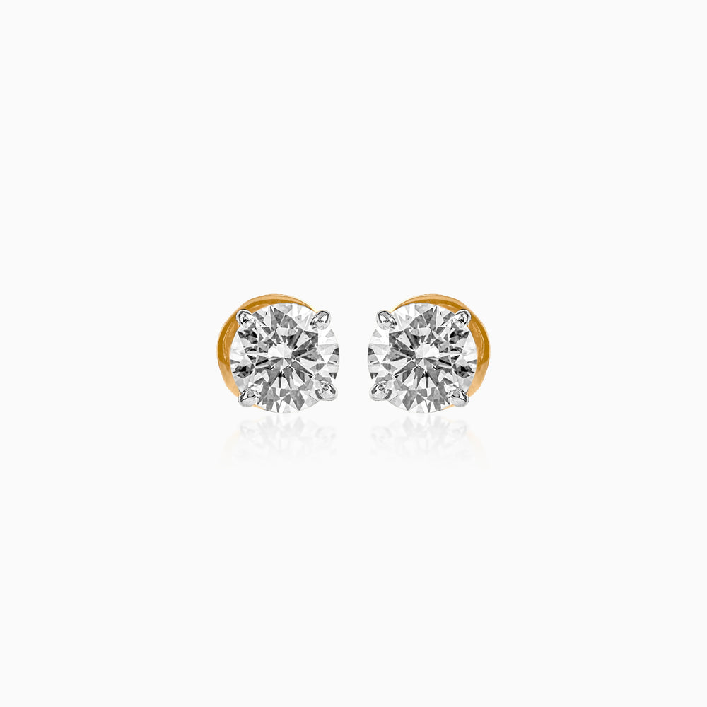 Gold-mounted round diamond stud earrings on white background