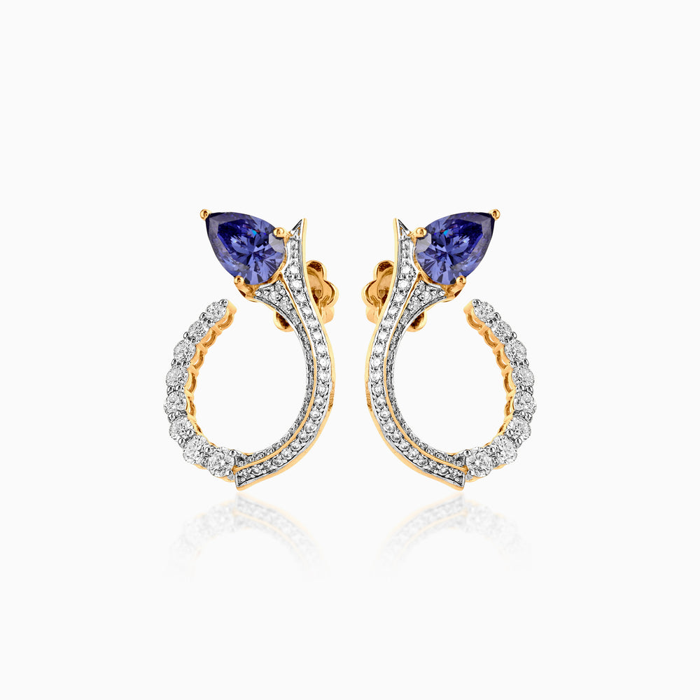 Gold and diamond earrings with blue sapphire trillion-cut stones in elegant curved design