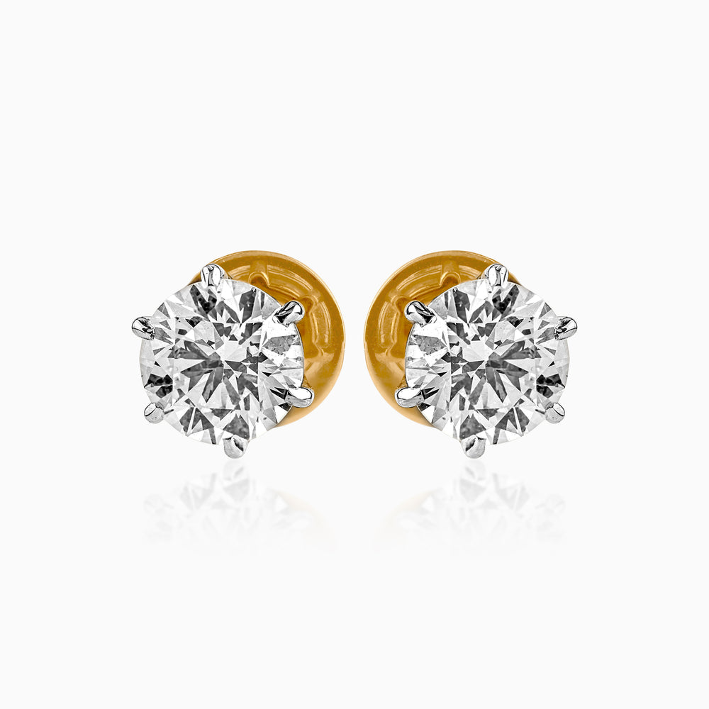 Pair of round diamond stud earrings with gold backs and silver prong settings
