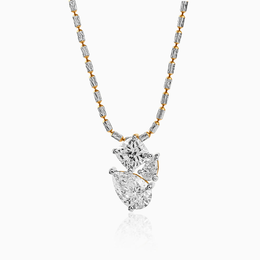 Two-tone diamond pendant necklace with mixed-cut stones on textured silver and gold chain