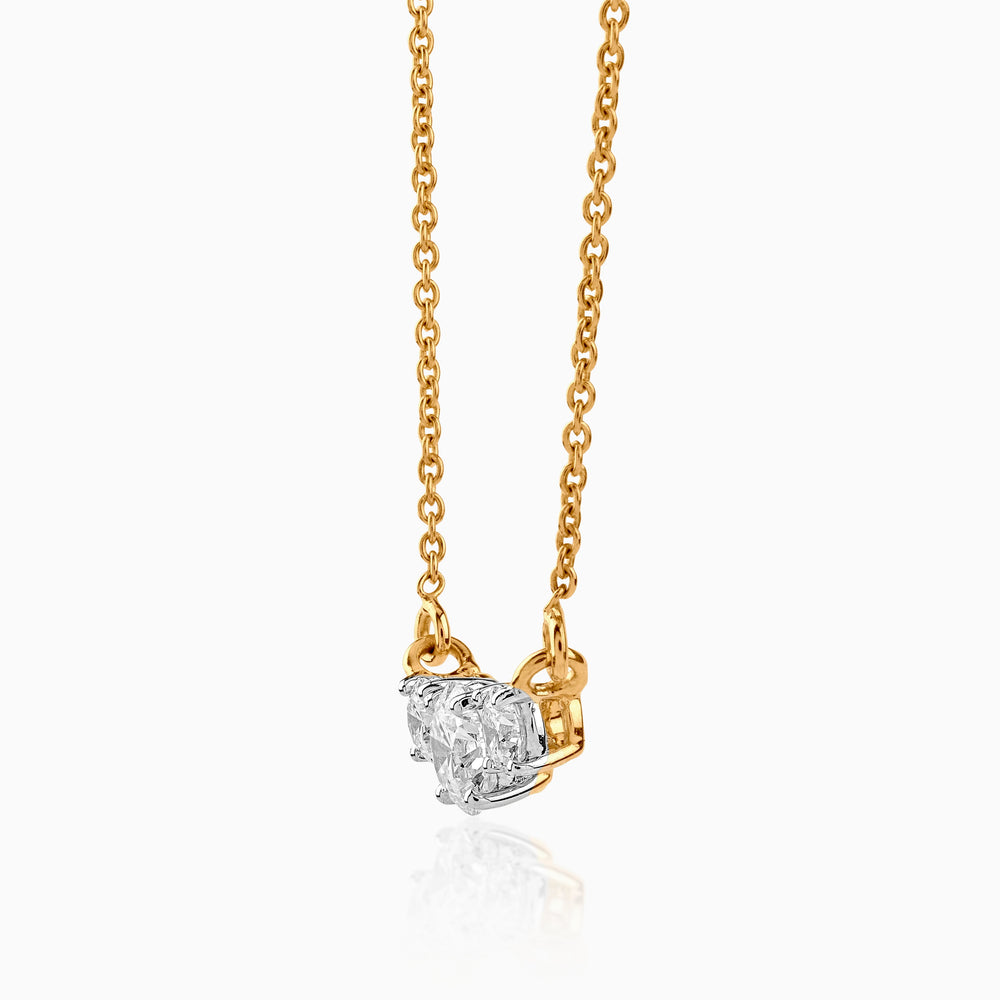 Gold chain necklace with radiant-cut diamond pendant, hanging against white background.