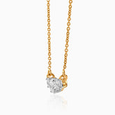 Gold chain necklace with radiant-cut diamond pendant, hanging against white background.