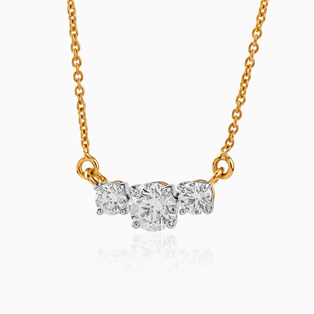 Gold necklace with three round diamonds on delicate chain, elegant and sparkling