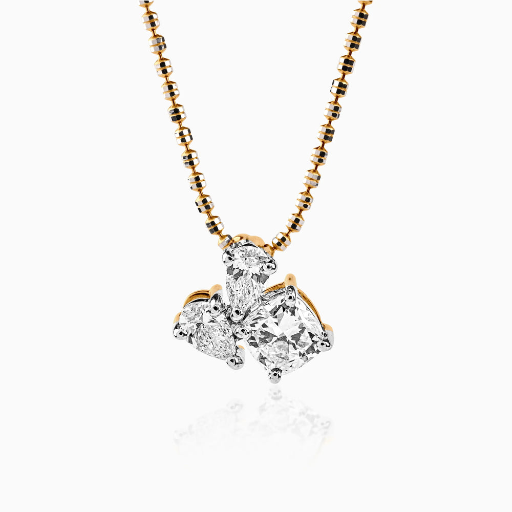 Gold chain with multi-cut diamond pendant in delicate cluster setting, gleaming against white background