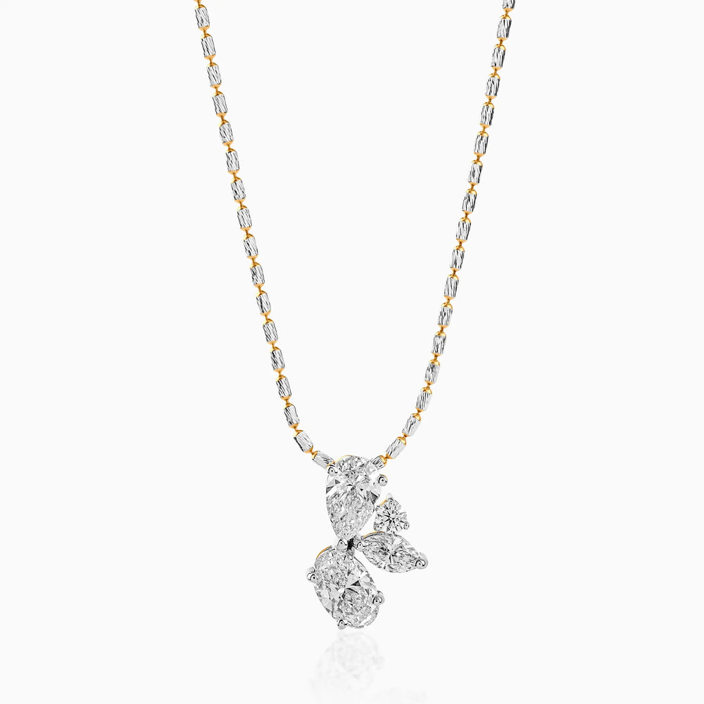 Gold and silver chain with multi-diamond clustered pendant in pear and round brilliant cuts.