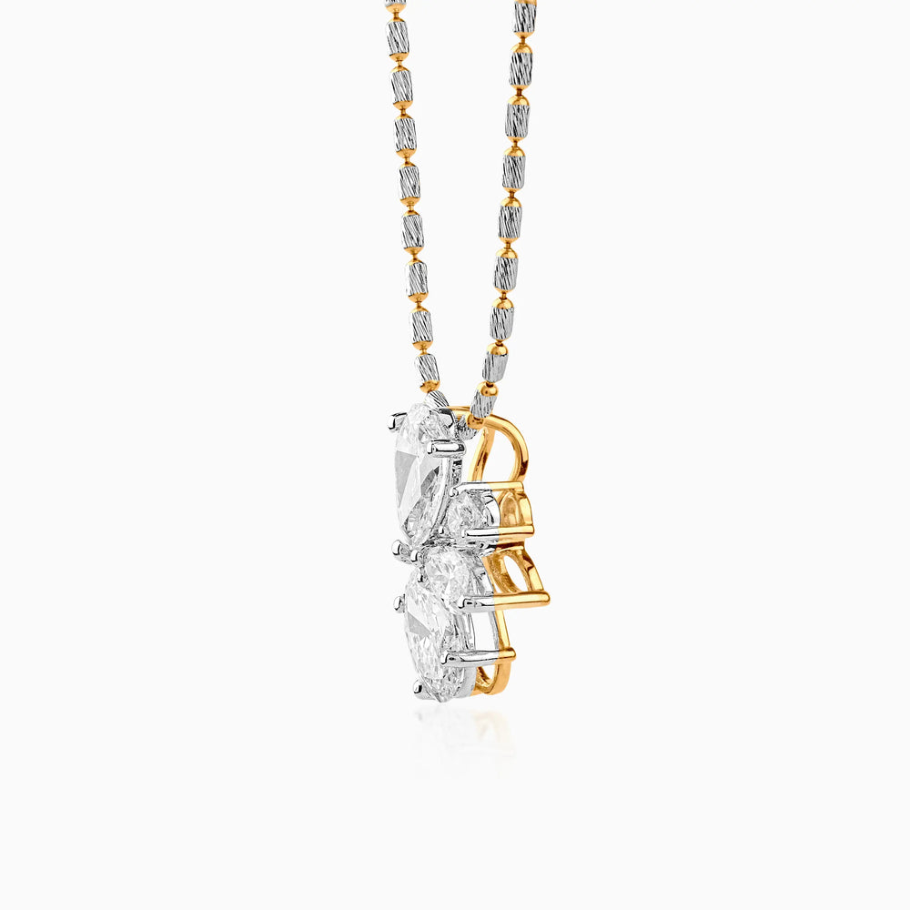 Diamond pendant with gold and silver chain, three-stone design hanging vertically