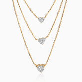 Gold necklaces with heart-shaped diamond pendants cascading at different lengths