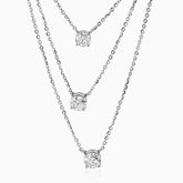 Three-tiered silver necklace with round diamond pendants on delicate chain links.