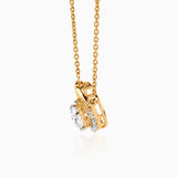 Gold pendant necklace with round diamond in intricate gold setting, hanging from delicate chain