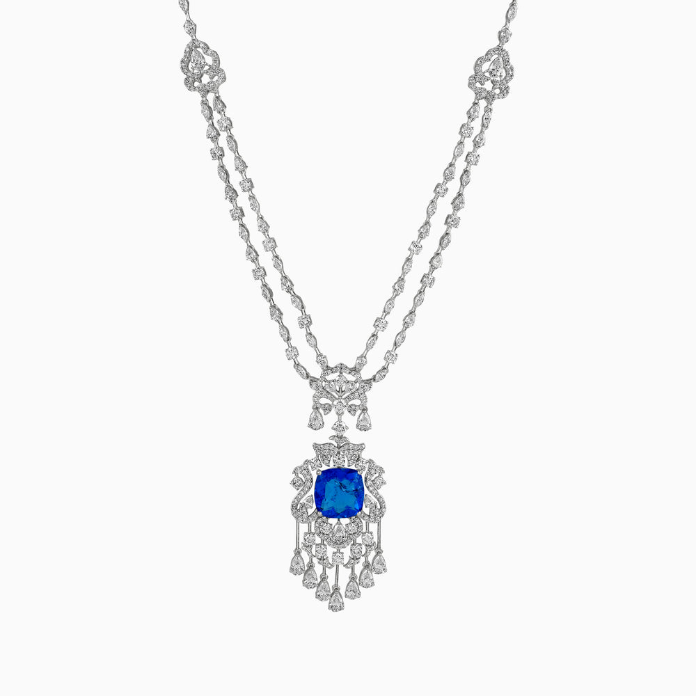 Intricate silver necklace with blue sapphire pendant, adorned with diamond-like stones