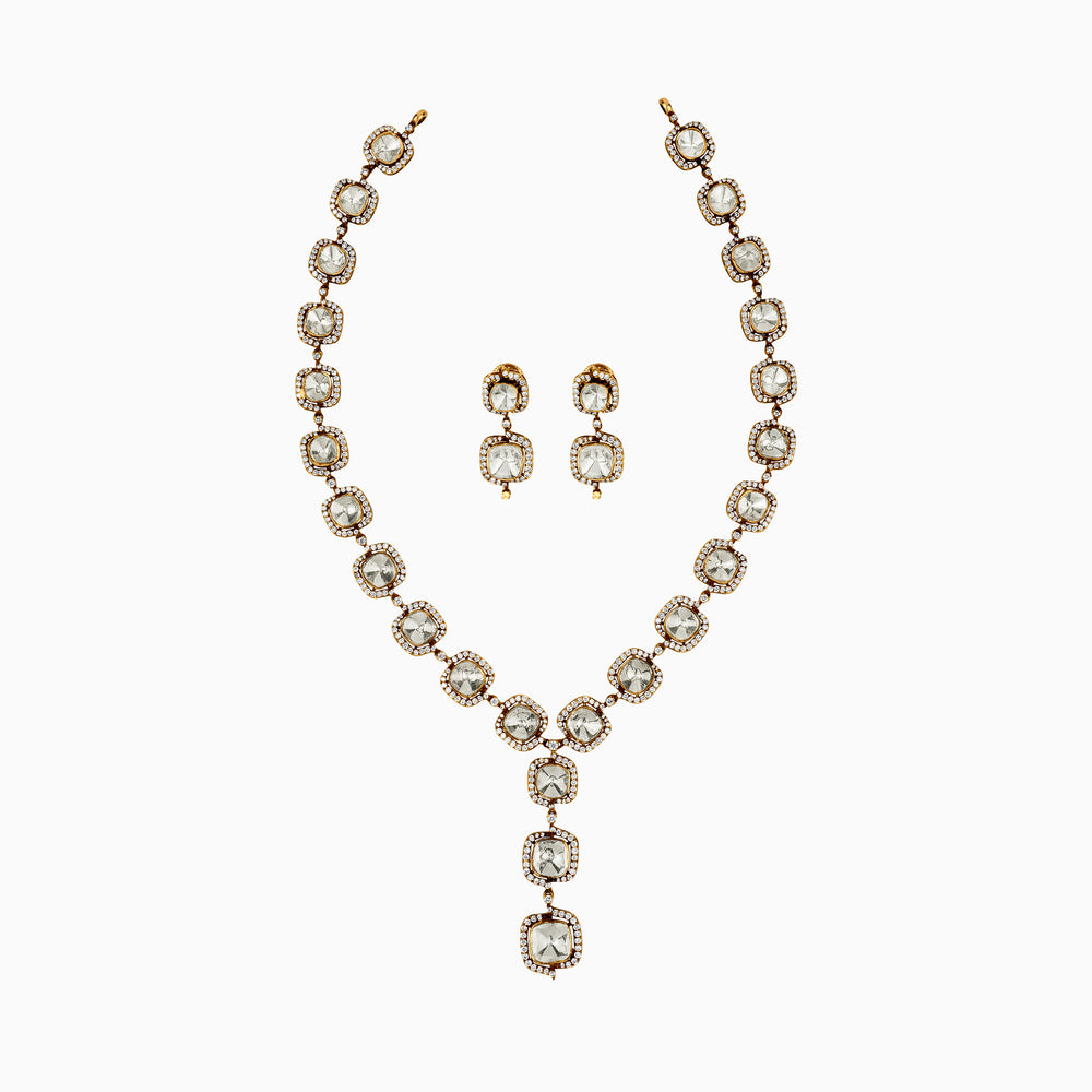 Elegant gold necklace and earring set with diamond-like stones in square and round settings