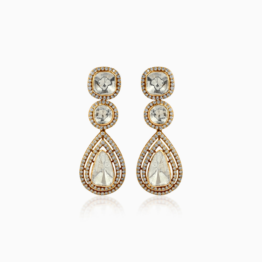 Gold drop earrings with diamond-encrusted halos and teardrop-shaped clear gemstones
