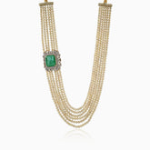 Multi-strand pearl necklace with emerald and diamond-encrusted pendant clasp.