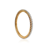 Delicate gold eternity band with diamond-encrusted edge, sparkling against white background