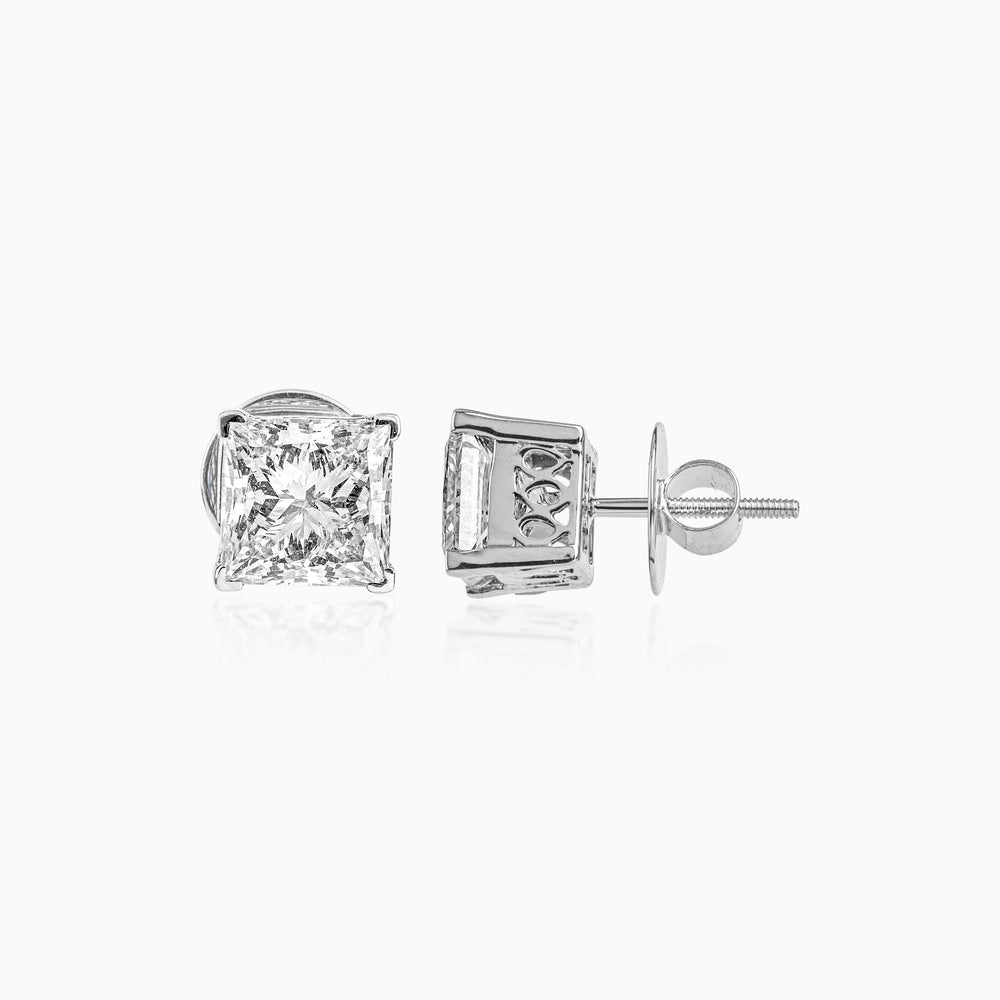 Silver princess-cut diamond stud earrings with ornate side detailing and screw-back closure