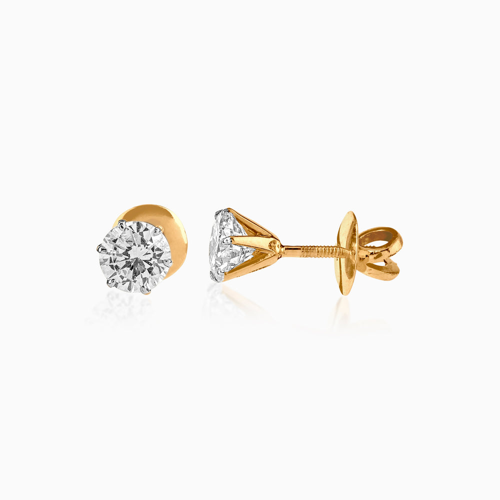 Gold earrings with round brilliant diamond studs, showcasing intricate setting and sparkle.