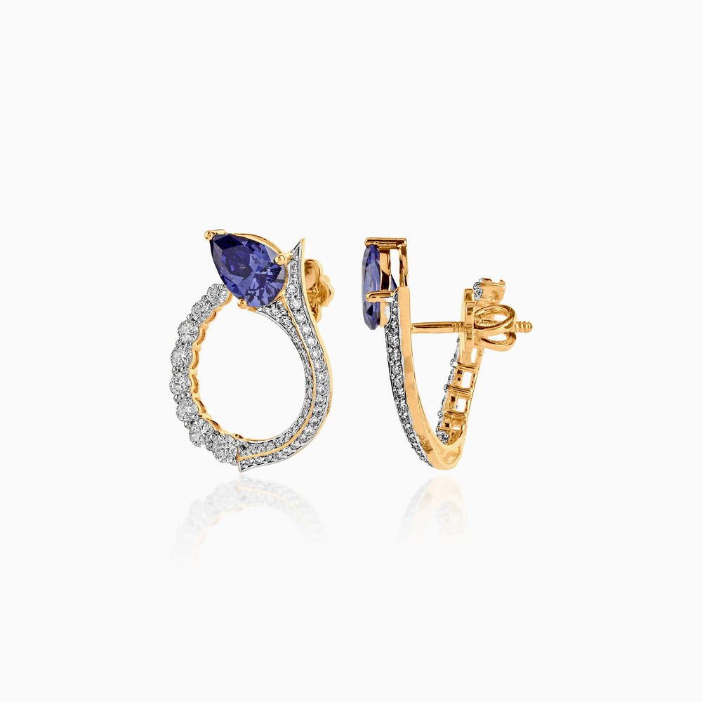 Gold and diamond earrings with pear-shaped blue gemstone, curved design with pavé stones
