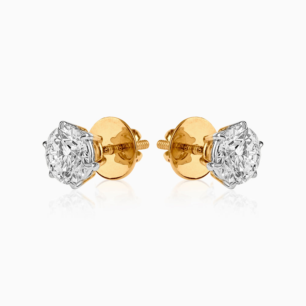 Diamond stud earrings with gold backs, round brilliant cut stones in silver settings
