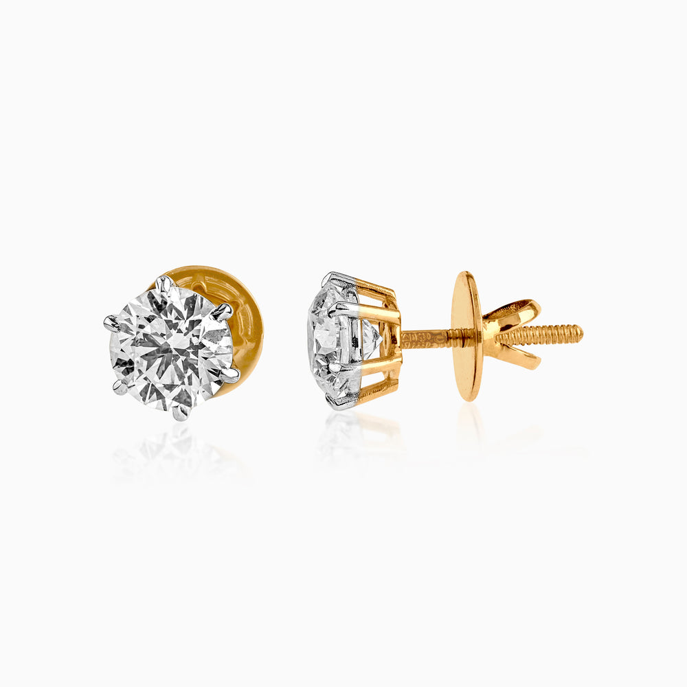 Gold and silver diamond stud earrings with screw-back closure and brilliant-cut stones