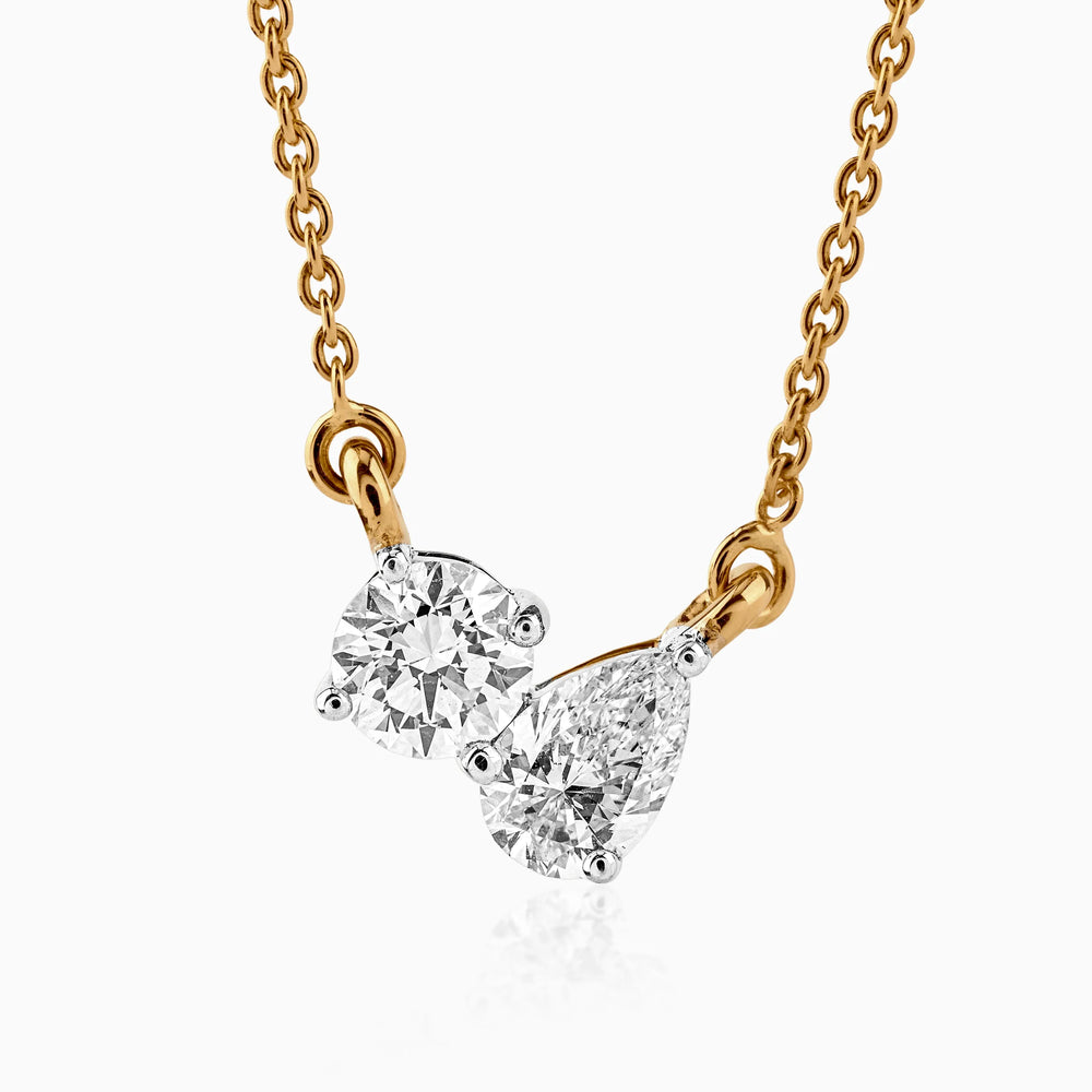 Gold necklace with two round and pear-shaped diamonds on delicate chain