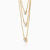 Gold layered necklace with three heart-shaped diamond pendants on delicate chains