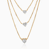 Gold necklaces with heart-shaped diamond pendants cascading at different lengths