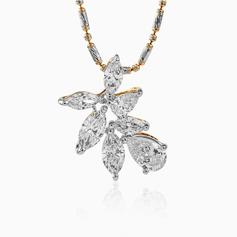 Diamond pendant with leaf-like design on two-tone gold and silver chain, sparkling with multiple stone cuts.