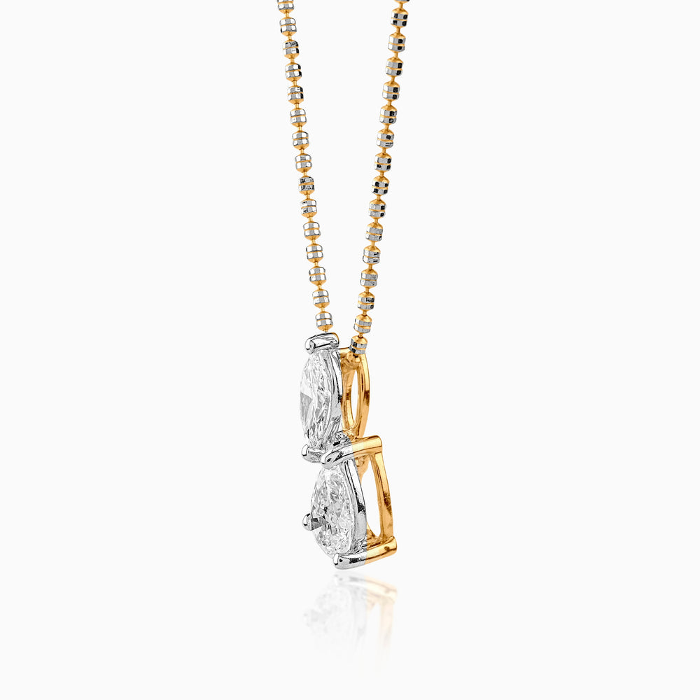 Two-tone diamond pendant on delicate gold and silver chain against white background