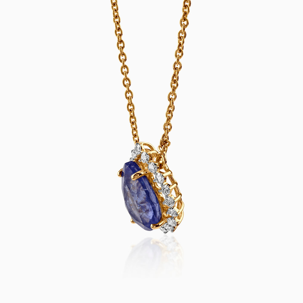 Gold necklace with blue sapphire pendant, accented by sparkling white diamonds.