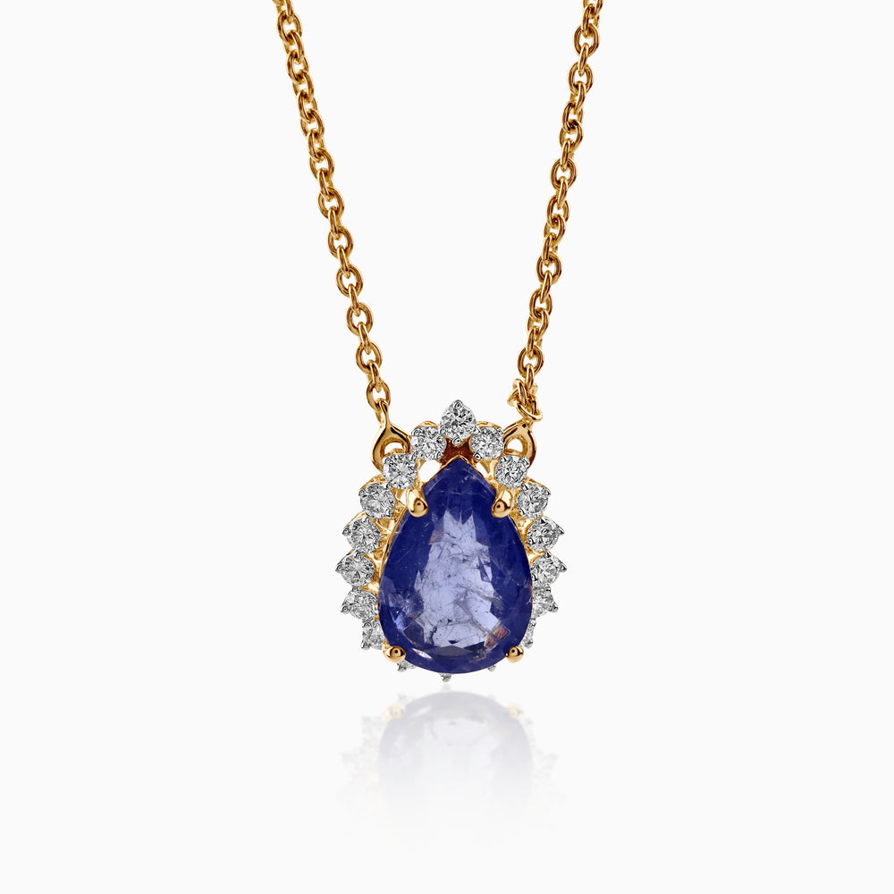 Gold necklace with teardrop sapphire pendant, surrounded by diamond halo on delicate chain