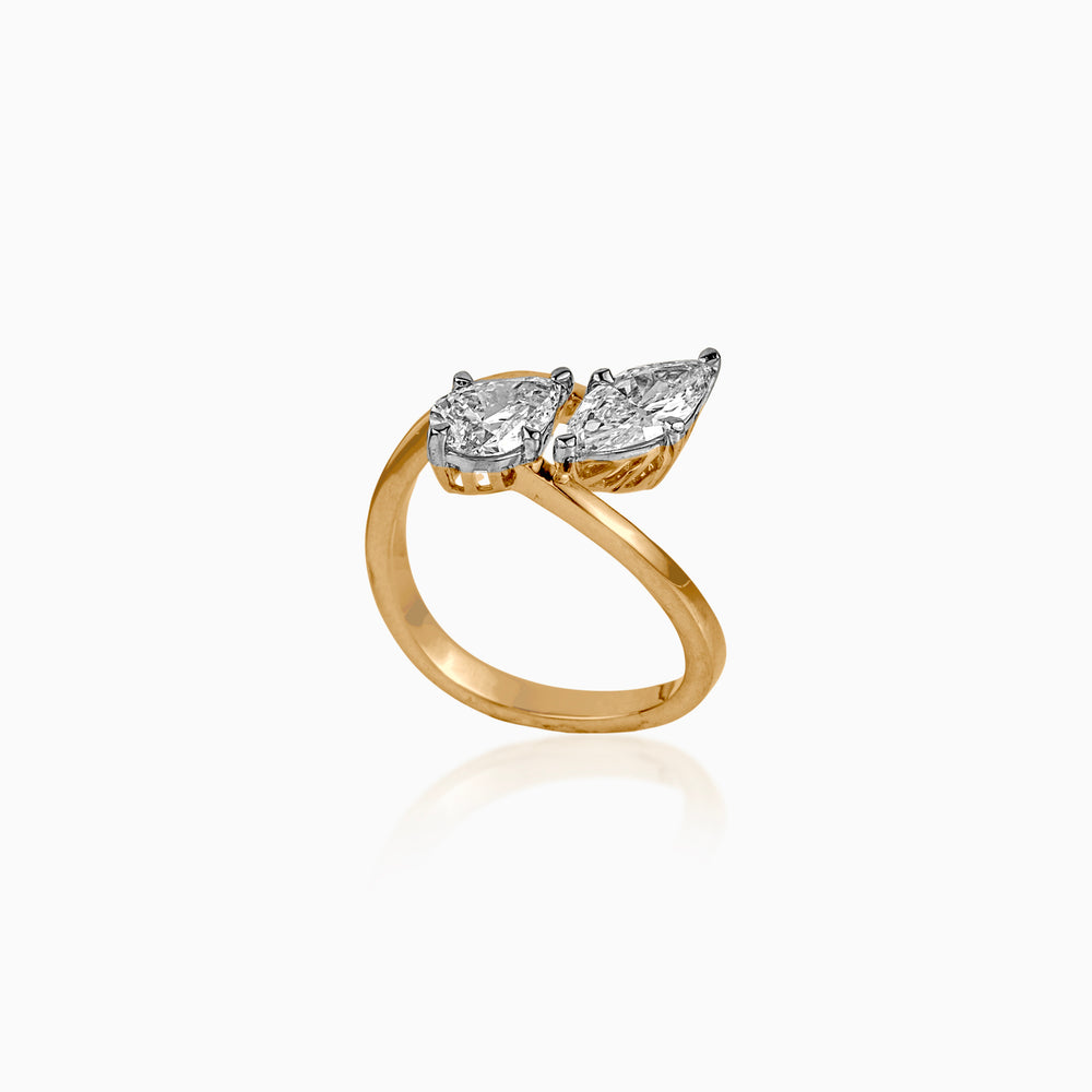 Gold ring with two pear-shaped diamonds in platinum settings, elegantly curved band