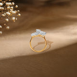 Gold ring with diamond cluster, delicate baby's breath flowers in soft-focus background