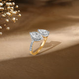 Gold and diamond ring with two pear-shaped stones, styled with delicate white flowers