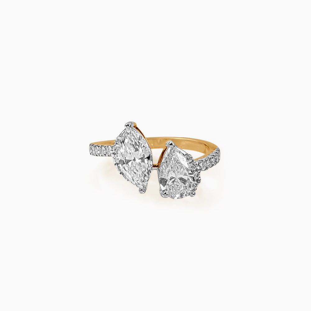 Two-stone diamond ring with marquise and pear-cut diamonds on gold and white metal band