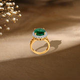 Gold ring with emerald center stone surrounded by diamond halo, elegant styling with baby's breath flowers.