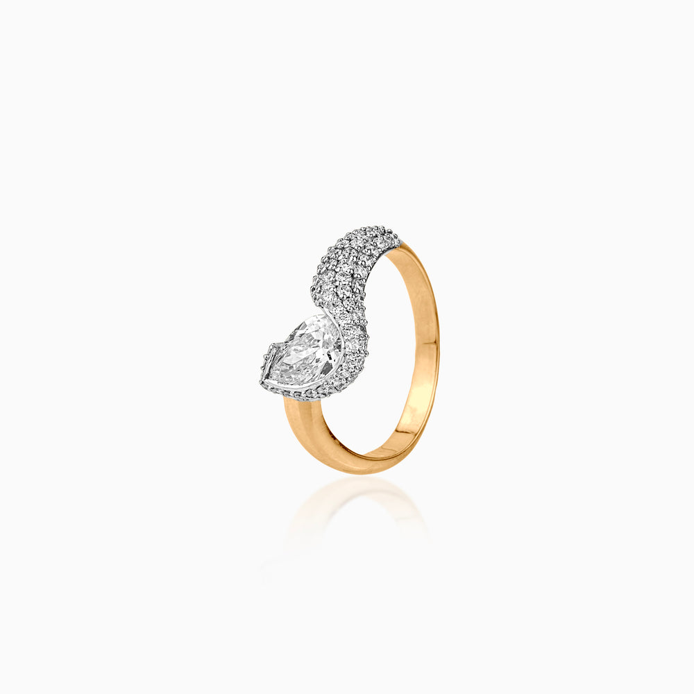 Gold and diamond ring with pear-shaped stone and pavé diamond band on white background