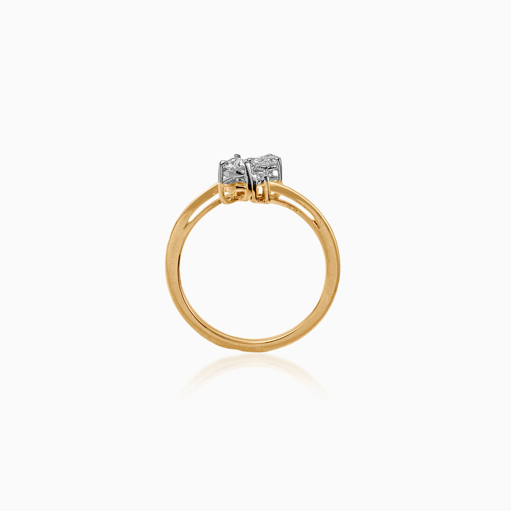 Gold ring with two diamonds set in white metal against white background