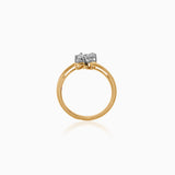 Gold ring with two diamonds set in white metal against white background