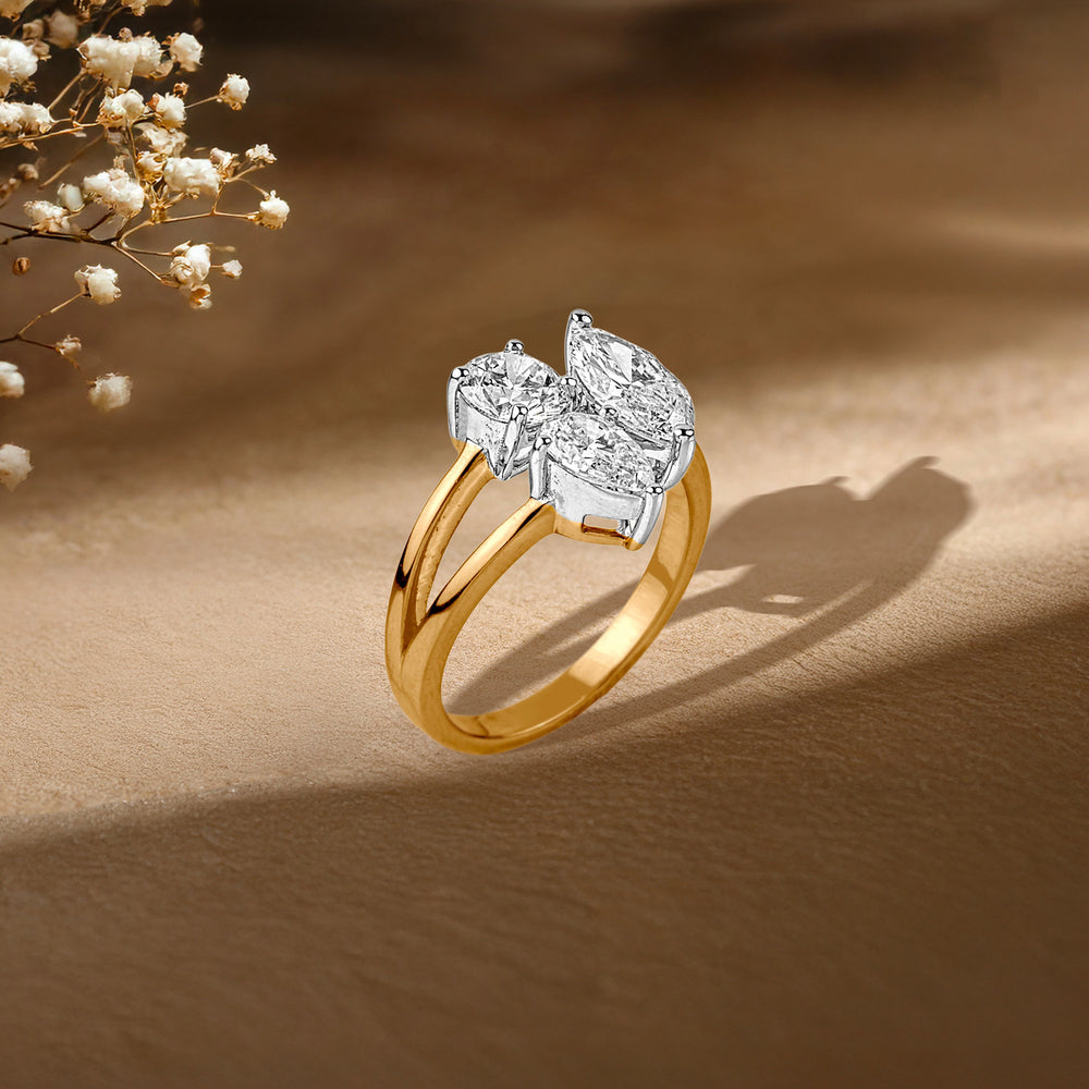 Gold ring with diamond cluster on textured background, delicate baby's breath flowers nearby