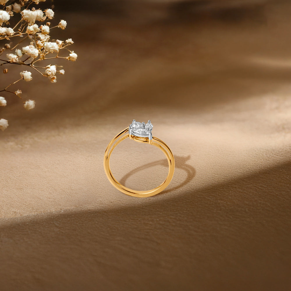 Gold engagement ring with diamond cluster, delicate baby's breath flowers in background