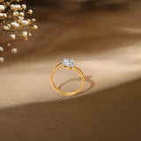 Gold engagement ring with diamond cluster, delicate baby's breath flowers in background