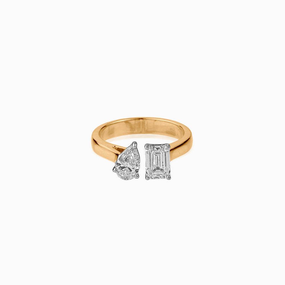 Gold ring with two mismatched diamond cuts: pear and emerald shapes in silver settings