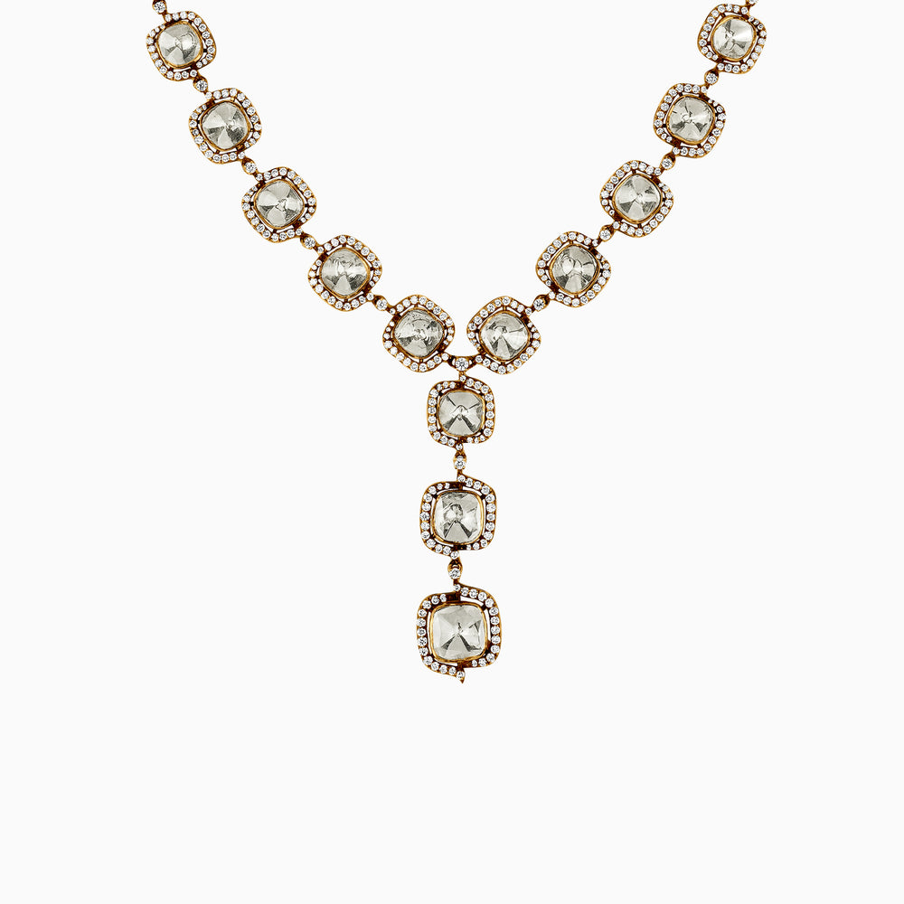 Gold necklace with cushion-cut stones and diamond-rimmed pendant drops