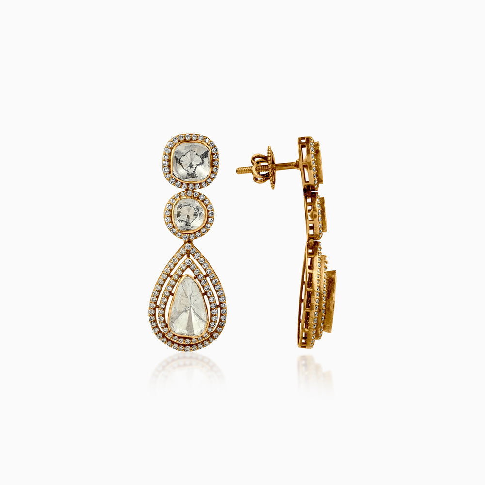 Gold teardrop earrings with diamond-encrusted halos, featuring three graduated stones